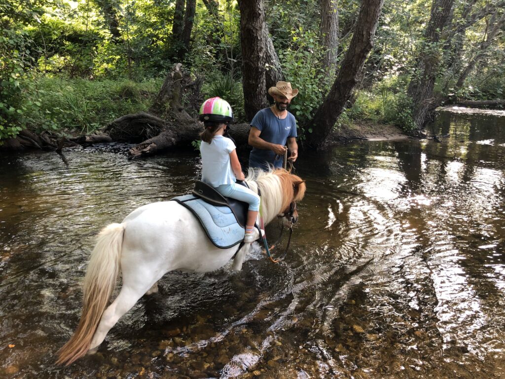 Giuseppe con pony e bimba nel fiume