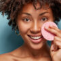 Healthy,Attractive,Positive,Woman,With,Afro,Haircut,,Keeps,Makeup,Sponge acidi esfolianti nei cosmetici