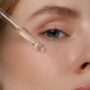 Woman,Applying,Essential,Oil,Onto,Face,,Closeup cosmesi medicale