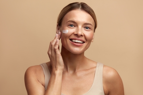 Skin,Care,Woman,Applying,Cream,On,Cheek.,Closeup,Of,Beautiful microbiota cutaneo